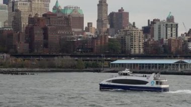 Şehir Feribotu Nehri 'ni geçiyor Skyline' ı geçiyor, Rıhtım Sahnesi Bulutlu Modern Yolcu Gemisi İskelelerle birlikte Dalgalı Su 'da süzülüyor.