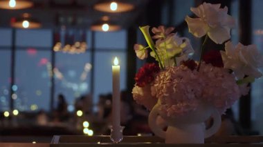 Şehir Işıkları, Ortancalar ve Beyaz Vazodaki Güller, Sıcak Yanan Mum, Bulanık Skyline