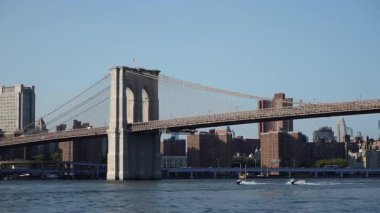 Açık Mavi Gök Altında Sakin Doğu Nehri 'ne uzanan Brooklyn Köprüsü Kulelerin, Kabloların ve Zamansız Şehir Trafiği' nin Geniş Görüş Alanı