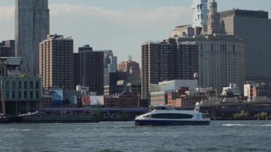 Rıhtımdan geçen feribot yoğun şehir merkezi peronu, gün ortası güneş ışığı pencerelerde parlıyor ve kaplama deniz etkinliği