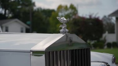 NEW YORK, ABD - 7 Ekim 2025: Kapüşonlu Beyaz Vintage Otomobil Izgarası Banliyö yoluna park edilmiş, Ağaçlı Mahalle Gün Işığında, Parlak Krom