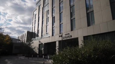 NEW YORK, ABD - 2 Ekim 2025: Bulutlu Gök Altında Modern Otel Cephesi, Beton Paneller ve Uzun Yansıtıcı Pencereler, İmzalı Giriş,