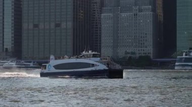 NEW YORK, ABD - 2 Ekim 2025: Sleek Catamaran Hız limanı, Modern Hızlı Feribot Kesikleri Skyline Siluetleri, Tayfa Dümende, Parlayan Gövde,