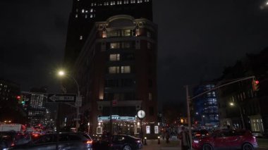NEW YORK, ABD - 4 Ekim 2025: Aydınlatılmış Kavşakta Gece Trafiği, Parlak Fren Işıklı Sıralar ve Taksiler, Yüksek Binalar, Yanıp sönen Sinyaller,