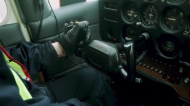 Eldivenli operatör uçak kokpitindeki kontrol kolunu manipüle eder, göstergeli göstergeler ve havacılık görevleri için anahtarlarla cihaz panelini renklendirir