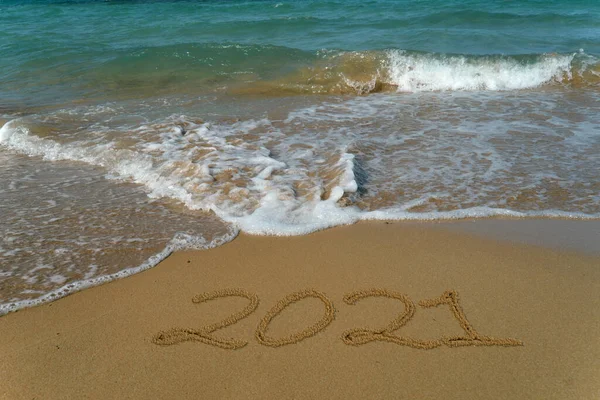 Happy new year 2021 written in the sand.Happy new year 2021 written in the sand by the sea.