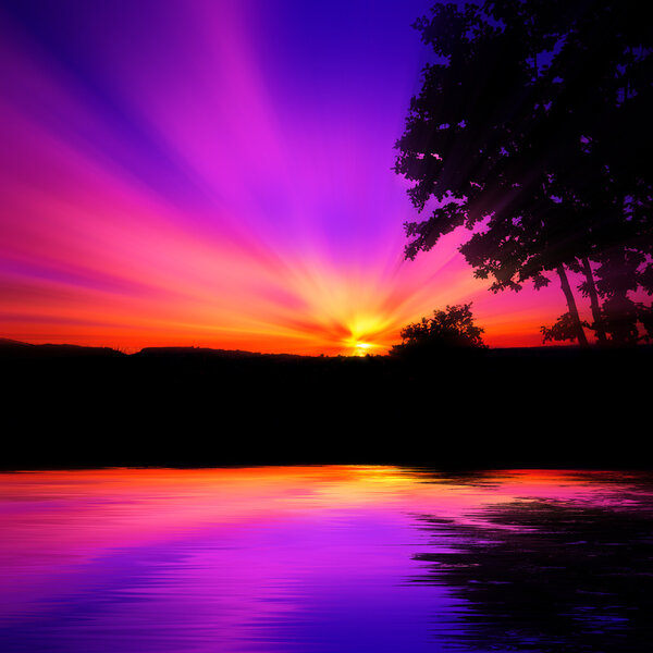 Red and purple sunset with rays of sun that stretch in the sky