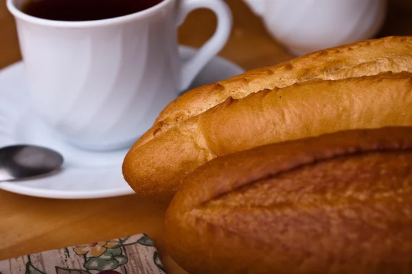 Pão francês com panela de chá e xícara em toalhas de mesa — Fotografia de Stock