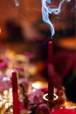 Sönmüş kırmızı bir mum. Fitilden duman çıkıyor. Noel yemeği. Yılbaşı tatillerinin sonu. Seçili odak ve bulanık arkaplan