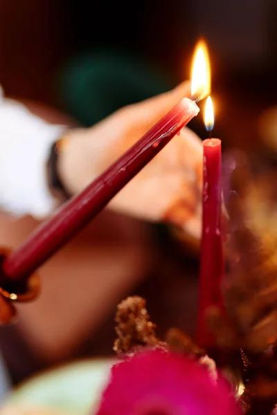 一个女孩在聚会上点燃了一根红色的蜡烛 选定的重点和模糊的背景 — 图库照片