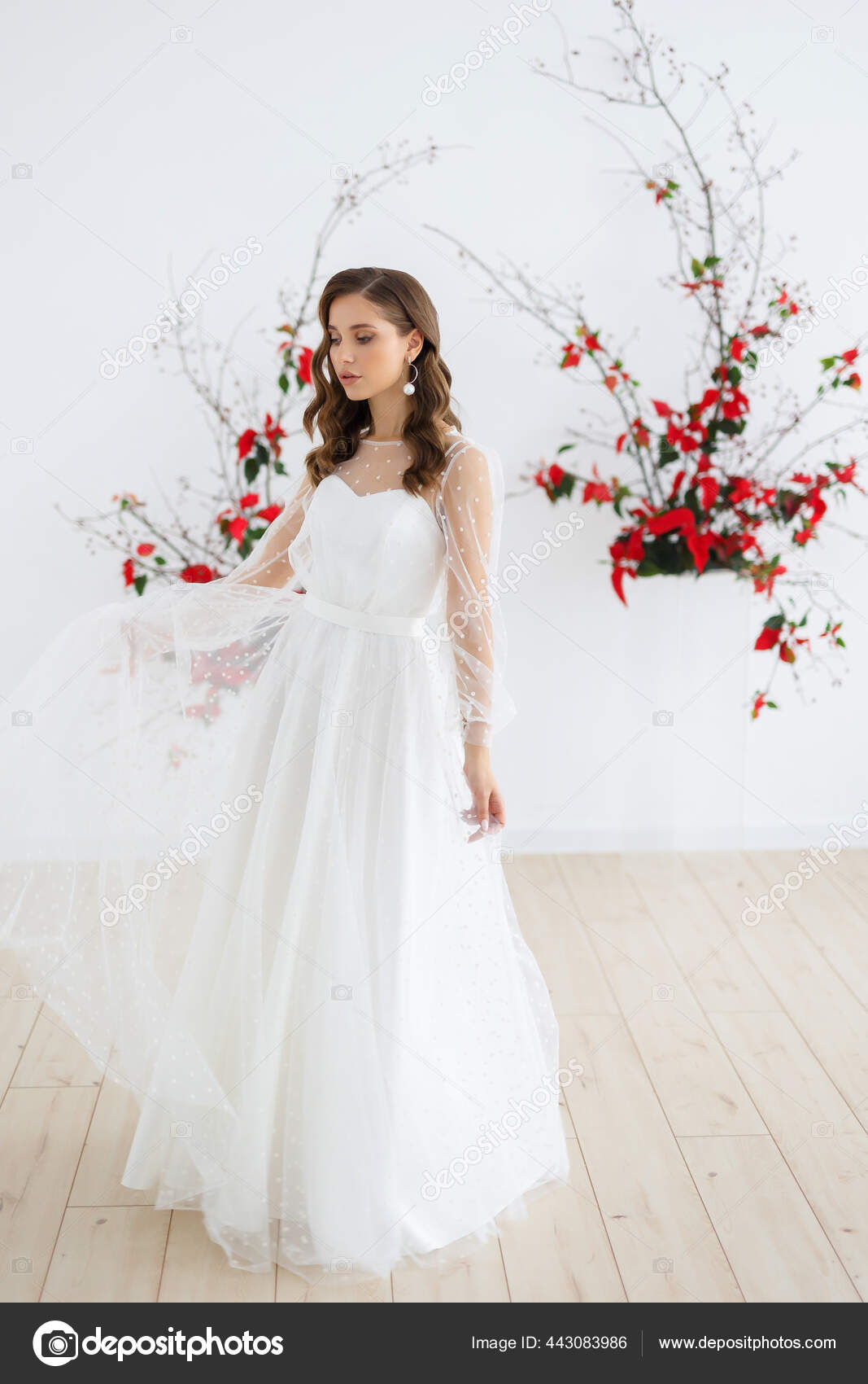 Bride in elegant white dress looking in the mirror. The bride smiles and  poses in front