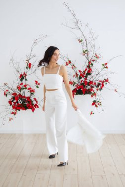 Beyaz pantolon giymiş, mutlu, modaya uygun bir gelin. Kırmızı noktalı kemer seremonisi. Düğün kış mevsiminde.