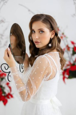 Genç bir kadının moda portresi. Gelin beyaz gelinlik içinde poz veriyor. Düğün trendleri ve konsepti.