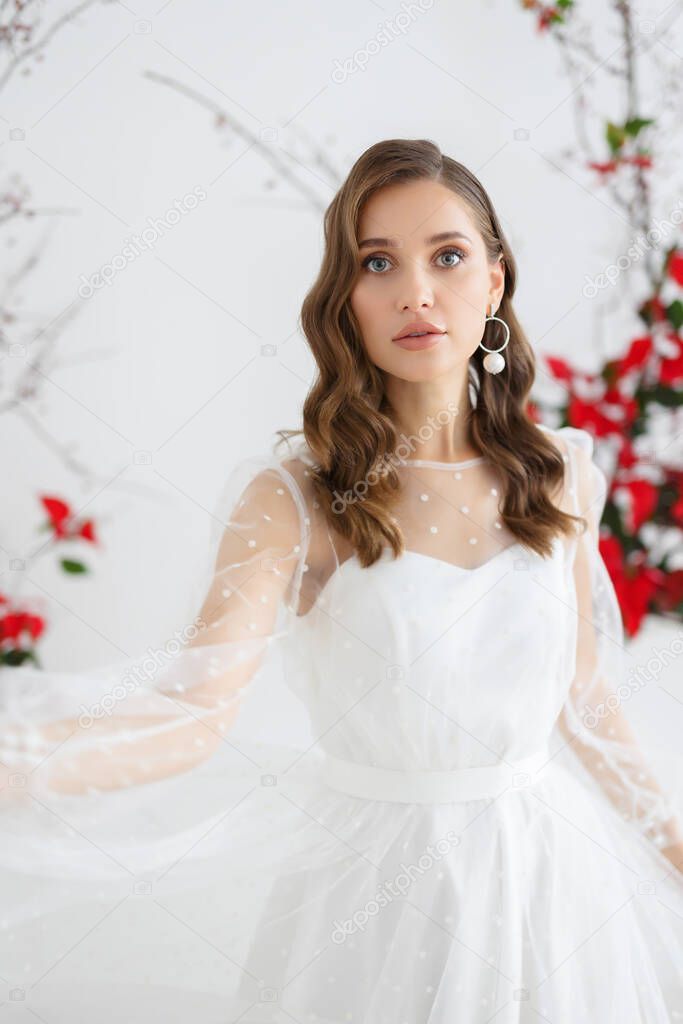 Fashion portrait of a beautiful bride in white dress polka dots