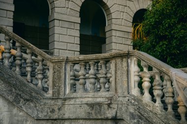 SOCHI, RUSSIA NOVEMBER 16, 2019: Günbatımında tropik ormanın ortasında Ordzhonikidze 'den sonra terk edilmiş sanatoryum. Taş merdiven ve kemer pencereleri görünüyor. Düğün için romantik bir yer.