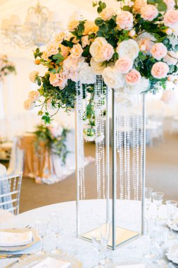 Masa hazır ve restorandaki misafirler için güllerle süslenmiş. Taze çiçek ve kristallerden yapılmış masa dekorasyonu