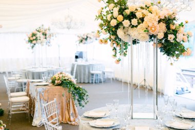 Masa hazır ve restorandaki misafirler için güllerle süslenmiş. Taze çiçek ve kristallerden yapılmış masa dekorasyonu