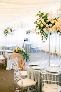 Masa hazır ve restorandaki misafirler için güllerle süslenmiş. Taze çiçek ve kristallerden yapılmış masa dekorasyonu