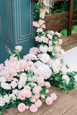 Avrupa tarzında modern bir tören. Orman gölünün ve ağaçların arka planında güller olan düğün kemeri. Taze pembe çiçek ve kristallerden yapılmış mücevherler..