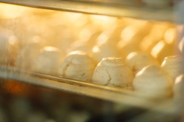 Beyaz kremalı çarşaflar fırında duruyor ve yemek pişiriyor.