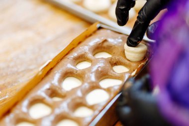 Pasta şefi bisküvinin içine bir pasta imalatçısı yerleştiriyor. Tatlıların ve keklerin seri üretimi.