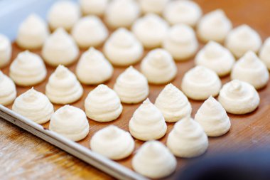 Şekerci mutfakta krema hazırlıyor. Pişirme çarşafında krema