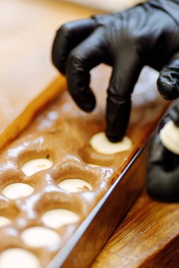 Pasta şefi bisküvinin içine bir pasta imalatçısı yerleştiriyor. Tatlıların ve keklerin seri üretimi.