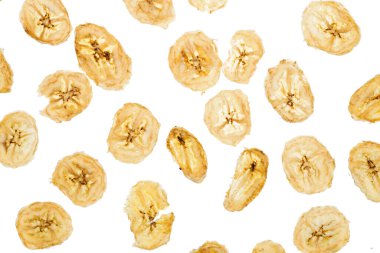 Şeffaf beyaz bir arkaplanda kurumuş muz dilimleri. Düzensiz konum