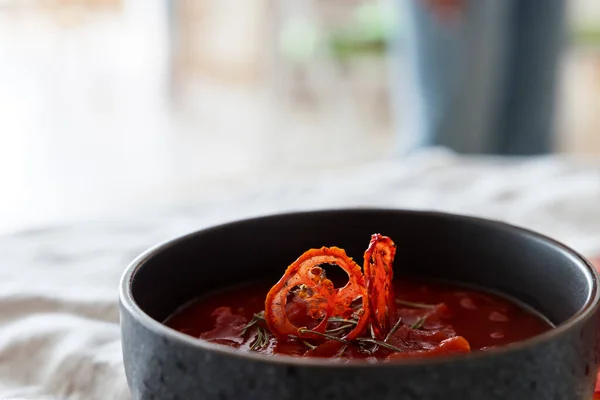 番茄酱汤 用晒干的西红柿装饰在撒满盐的桌子上 免版税图库照片