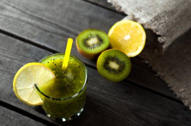 Taze kivi ve turuncu, ahşap masa üzerinde sağlıklı içecek.