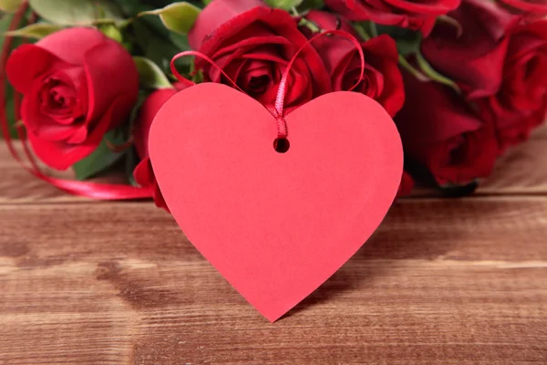 San Valentino sfondo del tag regalo e rose rosse su legno — Foto Stock