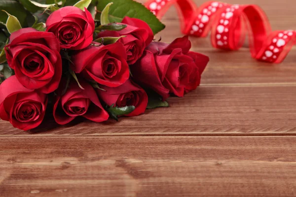 San Valentino sfondo di rose rosse e nastro su legno. Spazio per — Foto Stock