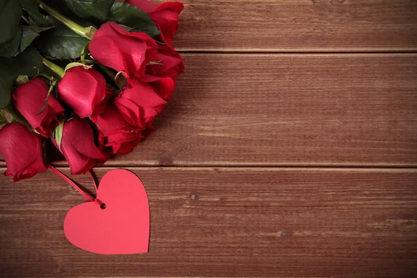 Fundo de Valentim de etiqueta de presente e rosas vermelhas em madeira. Espaço fo — Fotografia de Stock