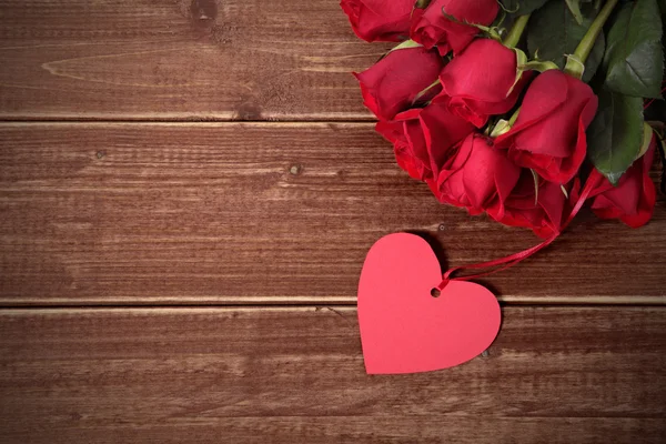 Valentinshintergrund aus Geschenkanhänger und roten Rosen auf Holz. Raum für — Stockfoto