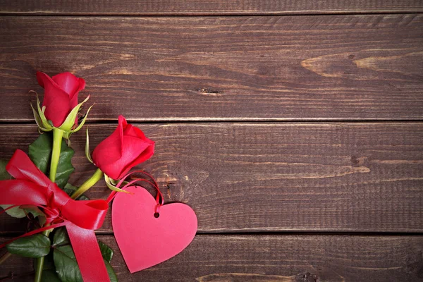 Fondo de San Valentín de etiqueta de regalo y rosas rojas en madera. Espacio fo —  Fotos de Stock