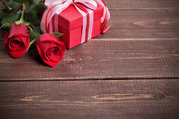 San Valentino sfondo della confezione regalo e rose rosse su legno. Spazio per — Foto Stock
