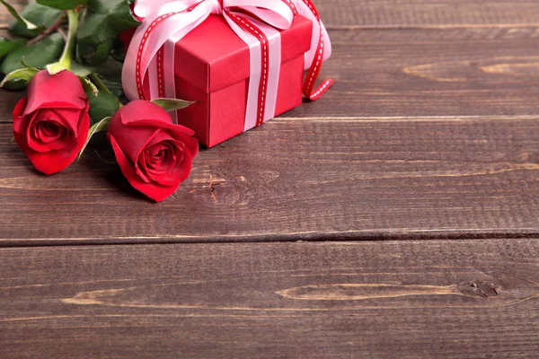 San Valentino sfondo della confezione regalo e rose rosse su legno. Spazio per — Foto Stock