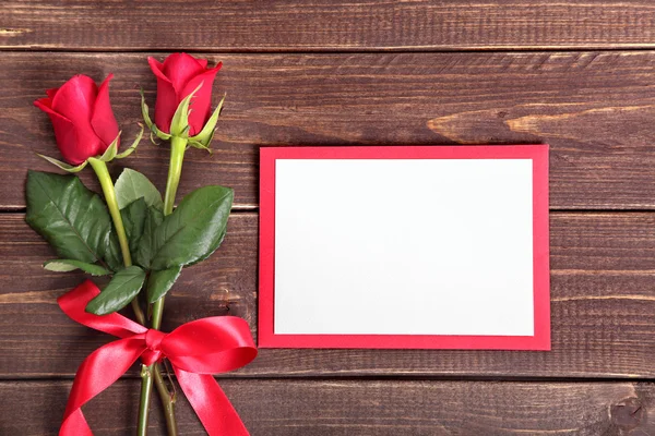 Fondo de San Valentín de rosas rojas y tarjeta en madera. Espacio para c — Foto de Stock