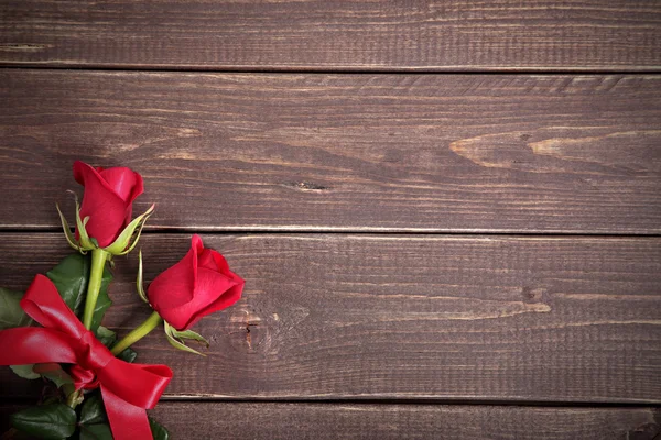 Alla hjärtans bakgrunden av två röda rosor på trä. Utrymme för kopia. — Stockfoto