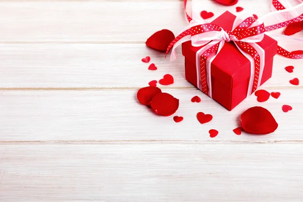 Alla hjärtans bakgrunden presentförpackning och rosenblad på vitt trä. — Stockfoto