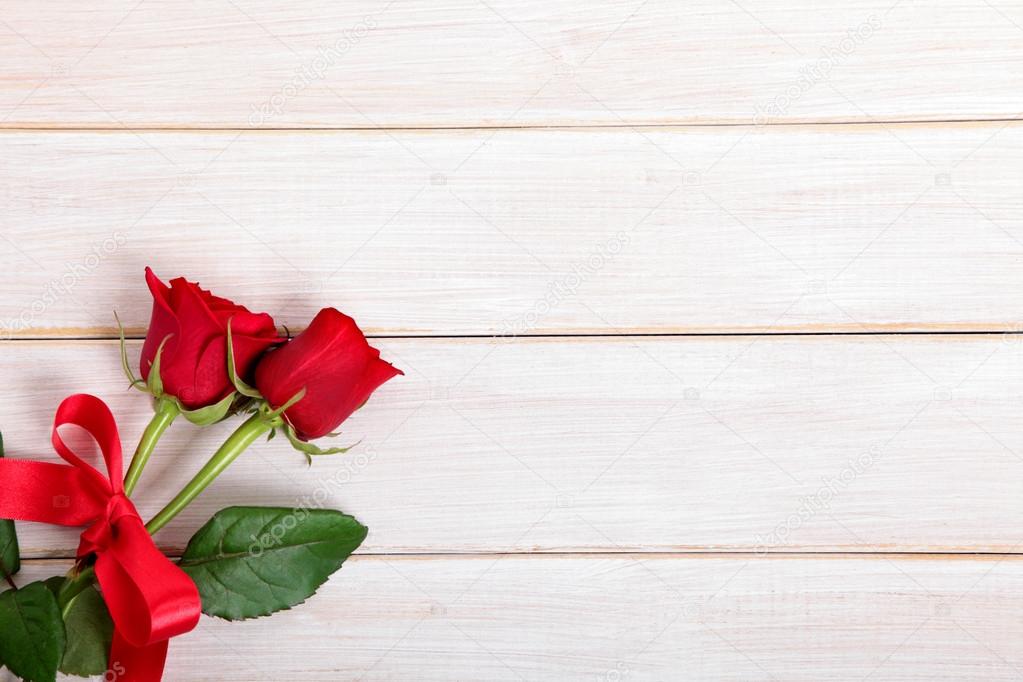 Valentine background of  red roses on  white wood. Space for cop
