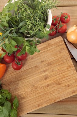 Boş bir kesme tahtası ile sebze ve otlar. Kopya için alan