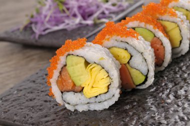 California roll suşi havyar ile siyah bir plaka üzerinde