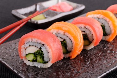 Yemek çubukları ile somon ve ton balığı suşi roll