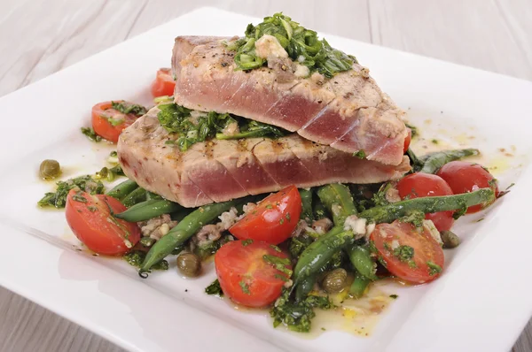 Жареный стейк из тунца с фасолью и томатным салатом — стоковое фото