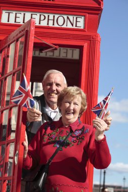 Kırmızı telefon ile üst düzey çift Londra'da kutu