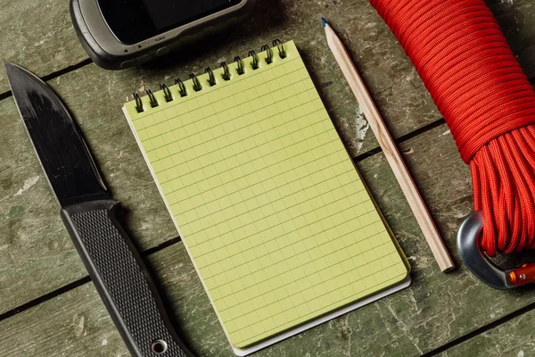 Overhead view of survival gear equipment to survive  and Notebook