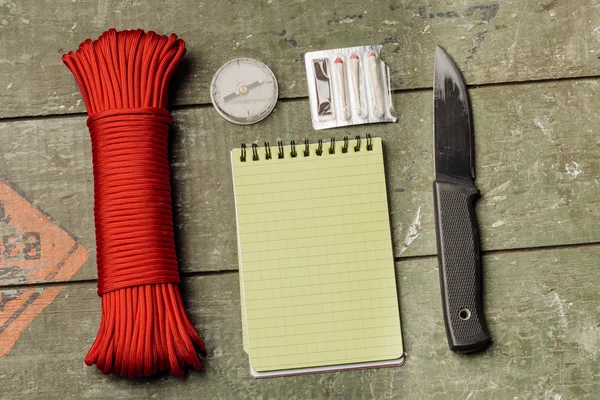 Overhead view of survival gear equipment to survive and Notebook