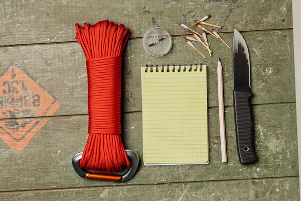 Overhead view of survival gear equipment to survive and Notebook