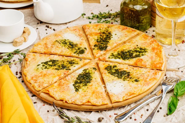 Foto de pizza crujiente en plato de madera, con botella de aceite de oliva — Foto de Stock